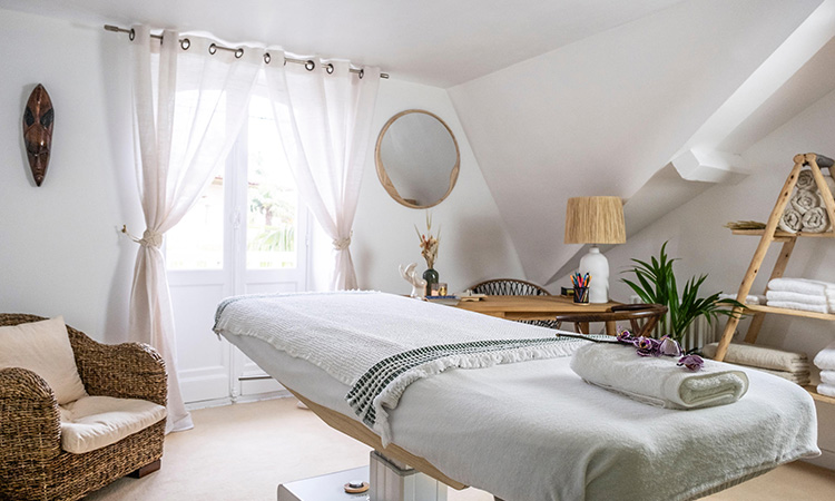 Découvrez la pièce de massage élégante d'Amazonia, un salon de massage haut de gamme sur la Côte Basque. Cette salle raffinée offre un espace cocooning parfait pour une expérience de bien-être et de détente absolue, avec une table de massage premium et une décoration apaisante.